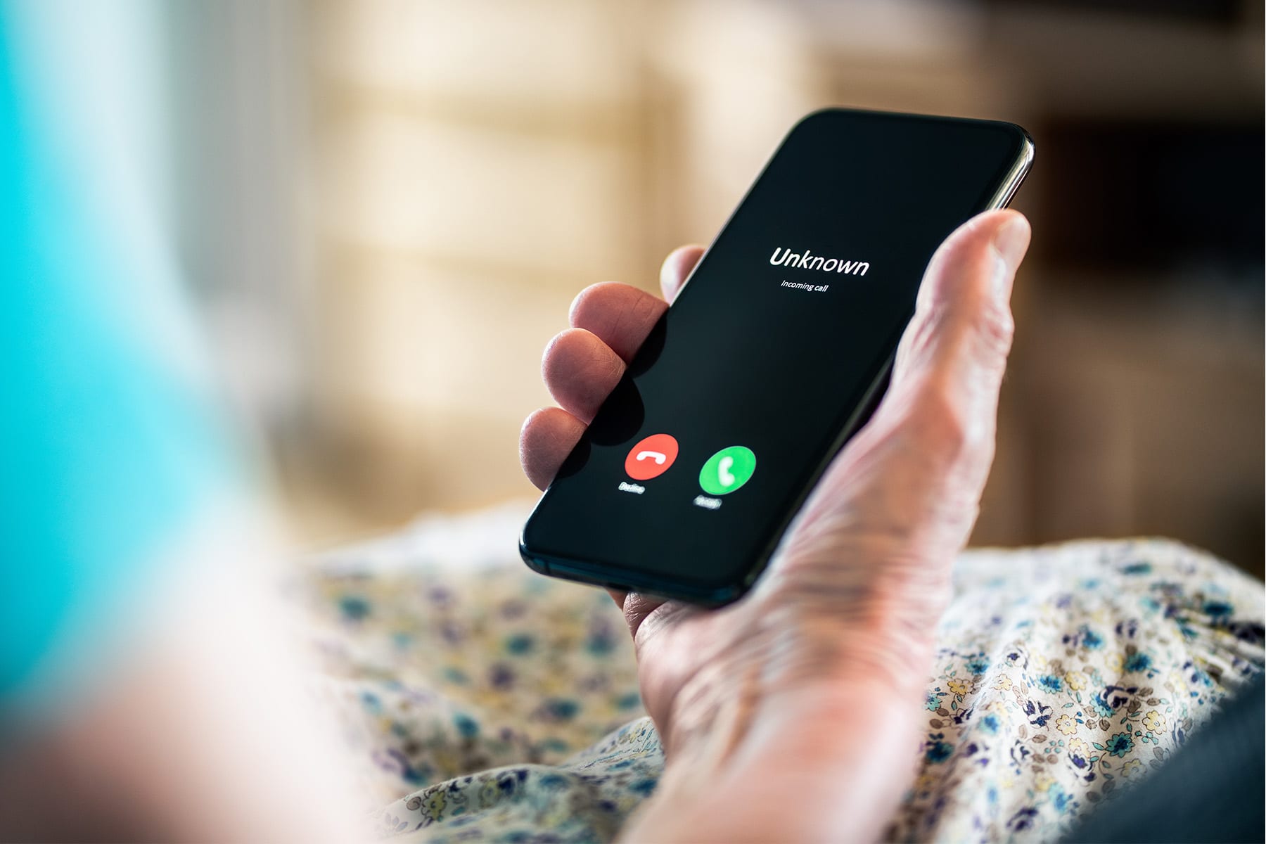 A close-up of a hand holding a mobile phone, representing the ability to quickly report fraud to BankNewport and take immediate action when fraudulent activity is detected on a personal or business account.