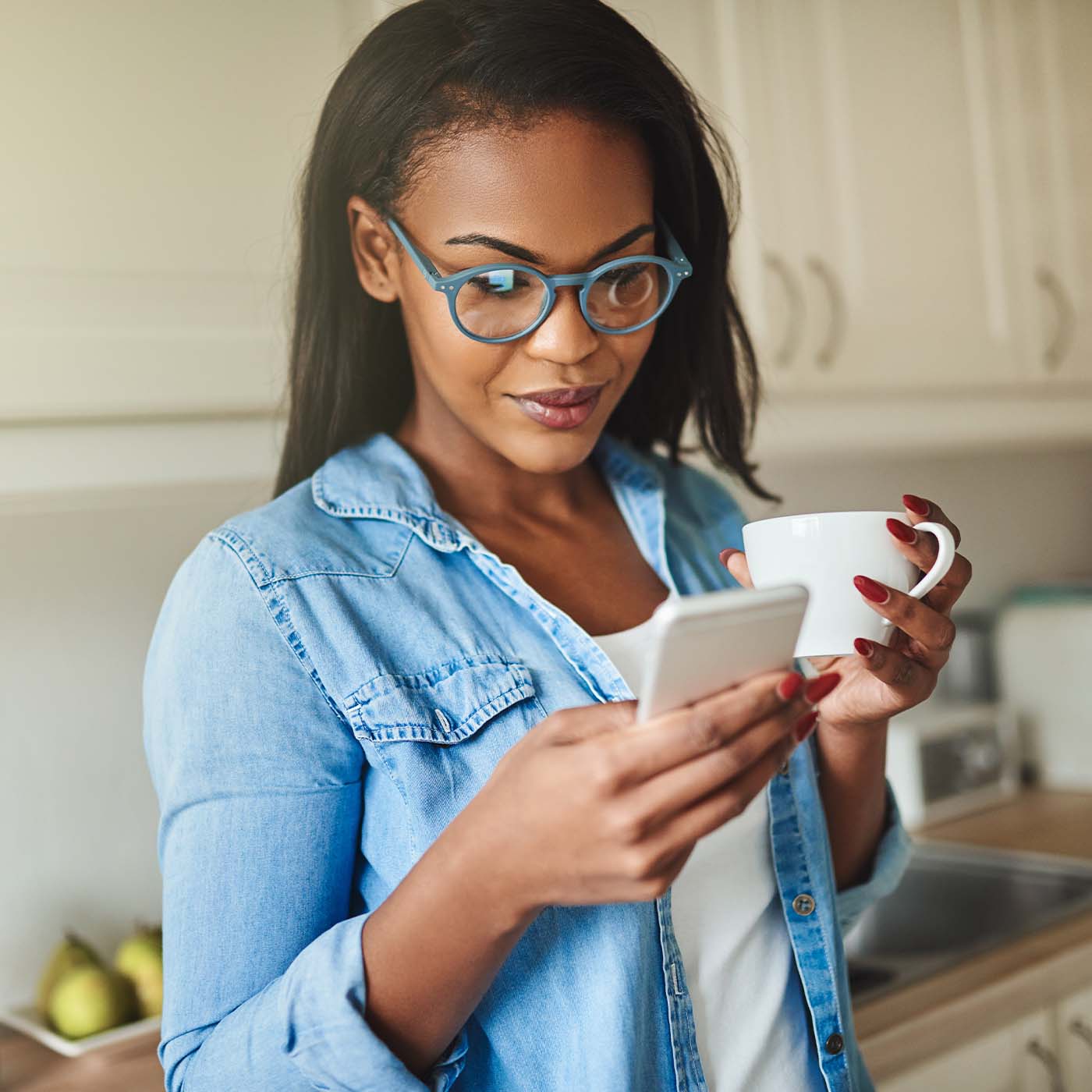 A smiling person stands in a bright sunlit room, representing the financial confidence and peace of mind provided by BankNewport's free credit score monitoring tools, allowing customers to check their credit score regularly at no cost.
